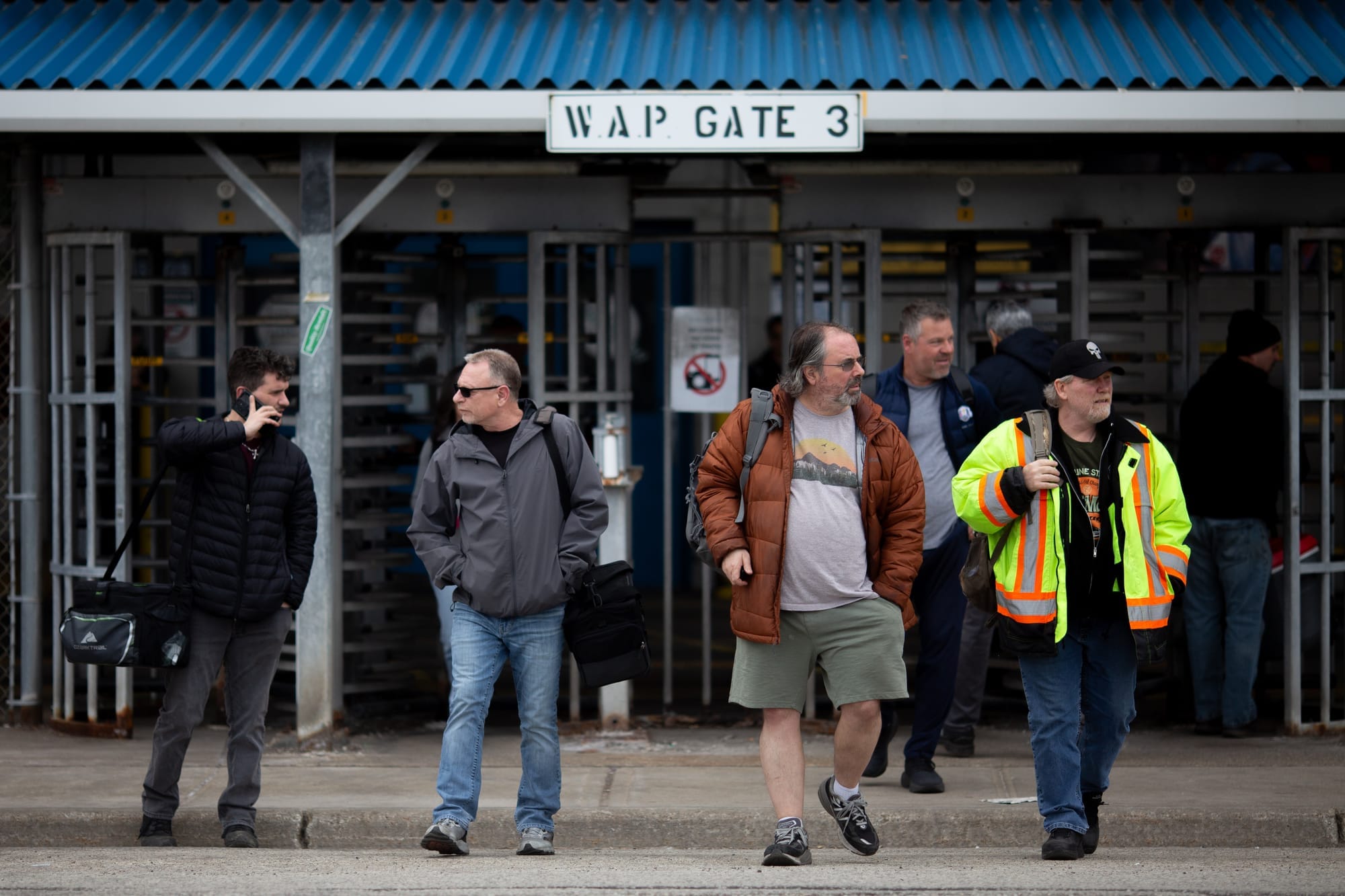Five men walk out of doors as they leave their last shifts before a two week shutdown at the Stellantis plan