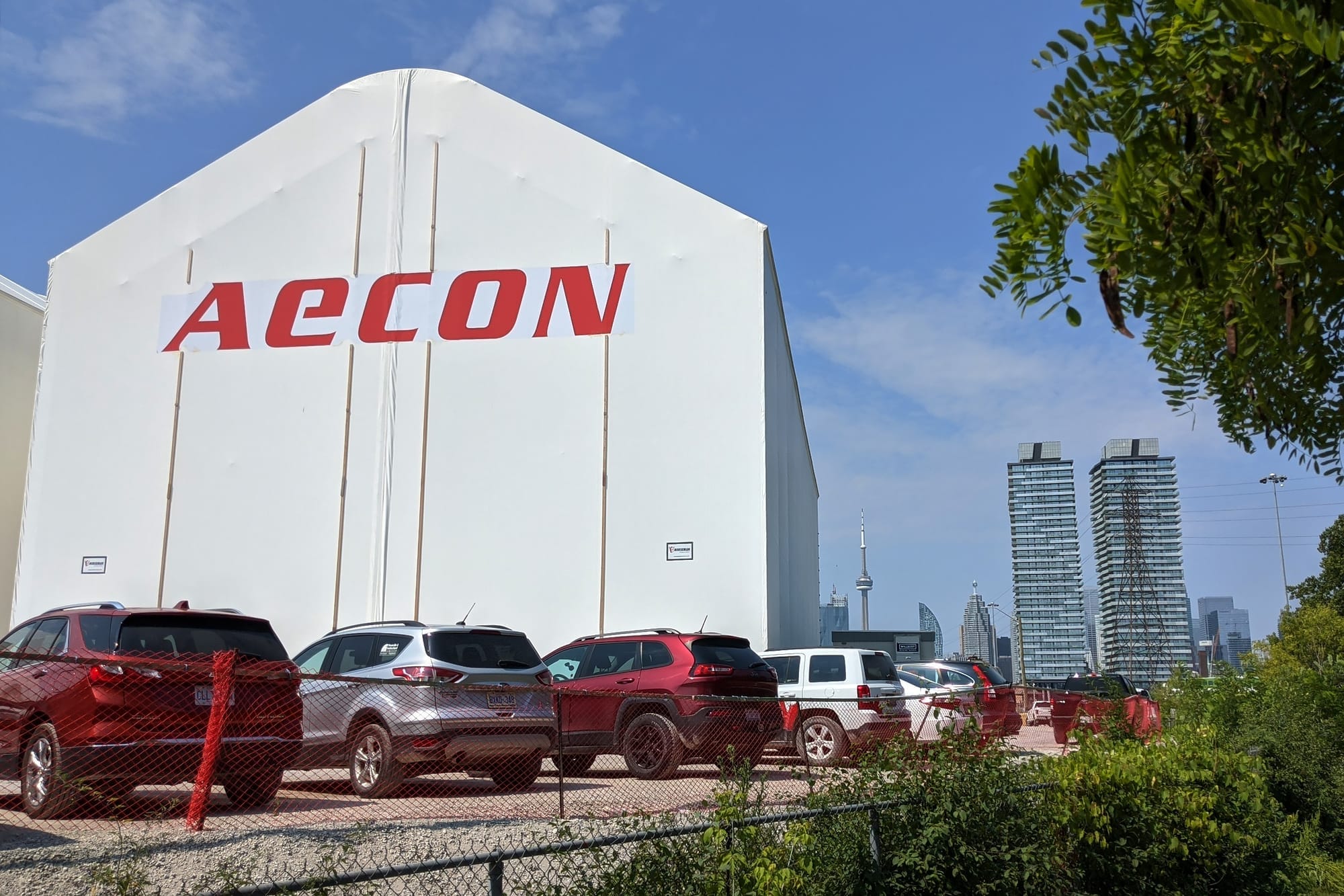 A large white tenet with the words AECON, with the CN tower in the background