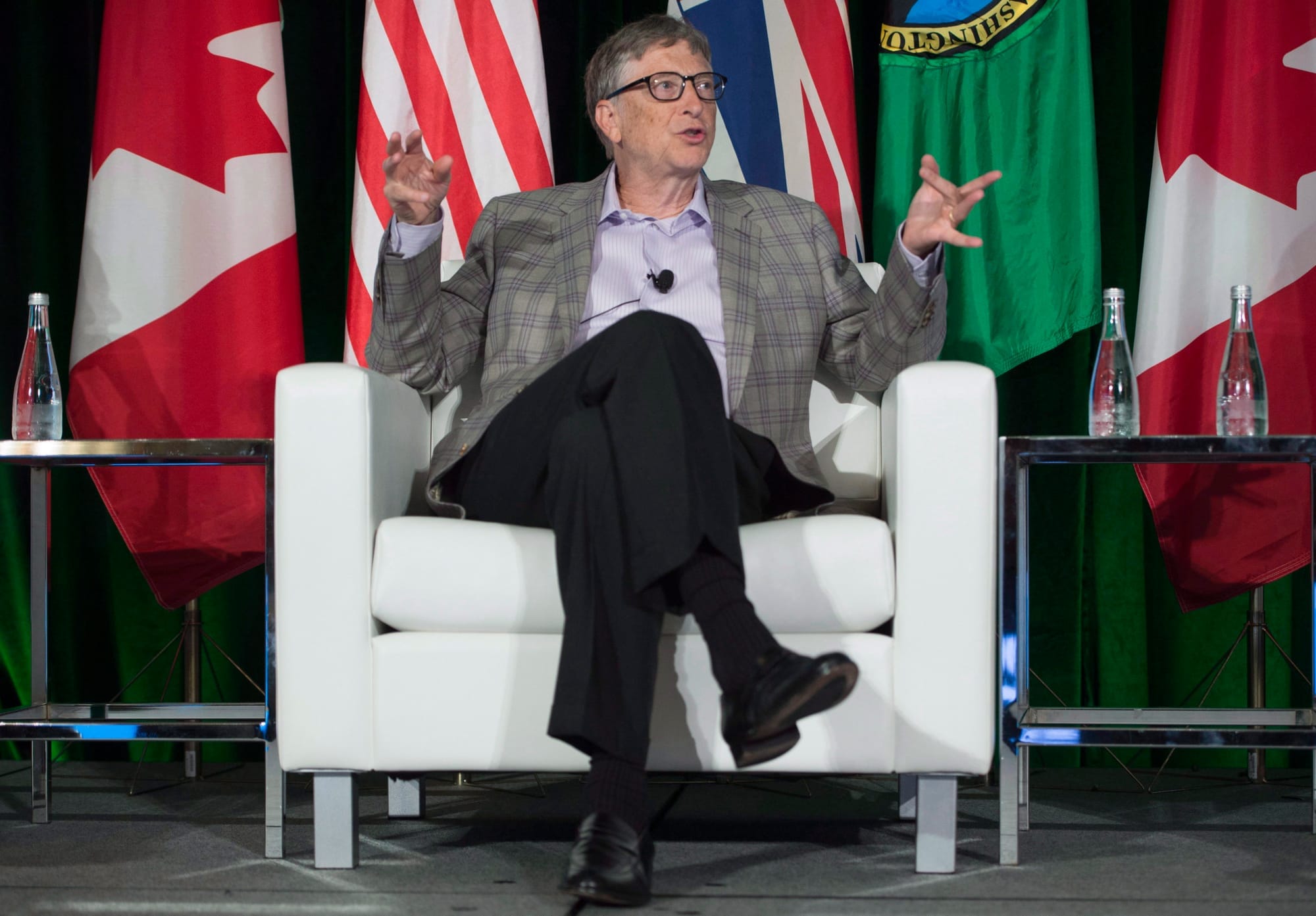 Microsoft co-founder Bill Gates sits in a white armchair at a conference in 2016.
