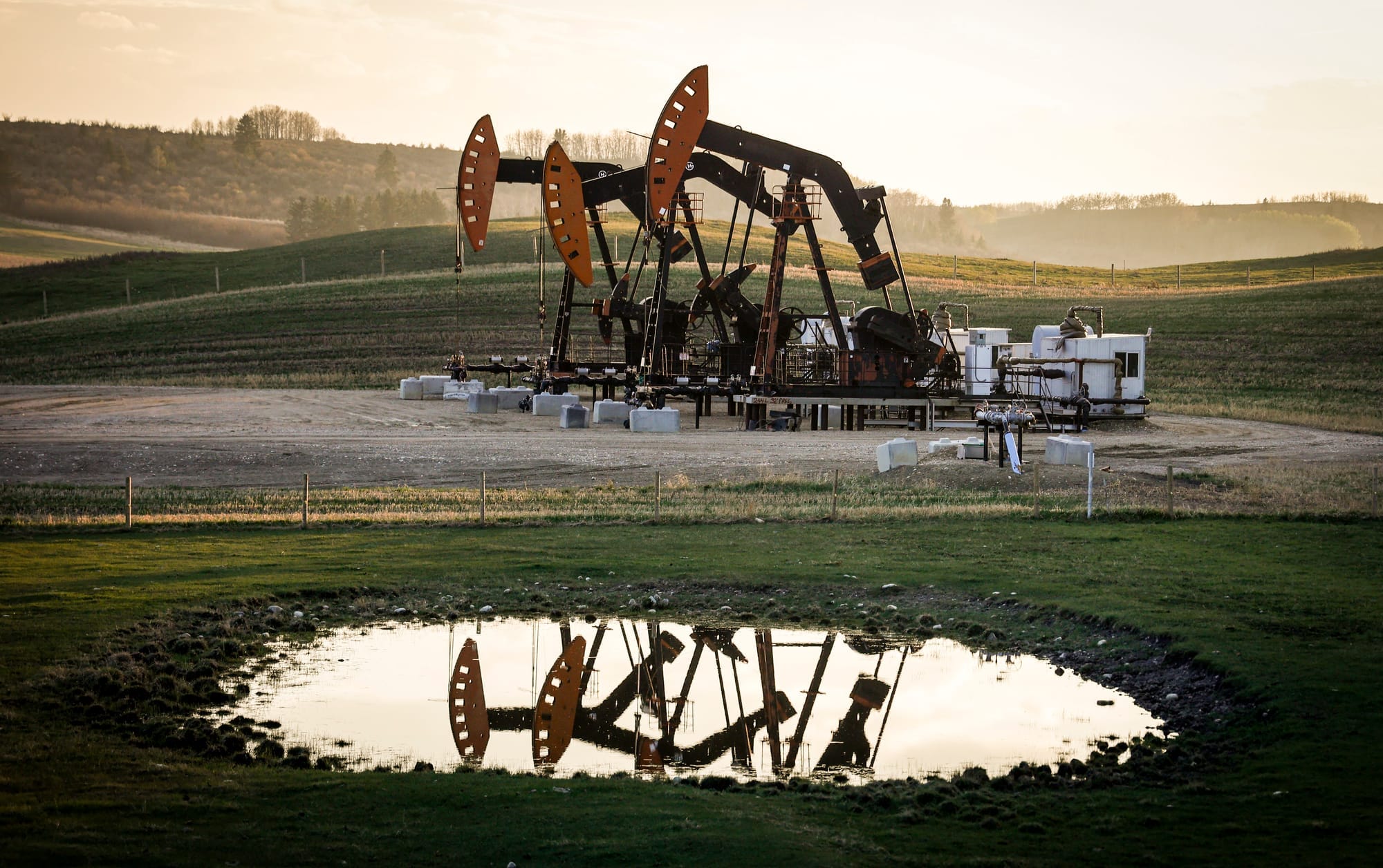 Pumpjacks draw out oil and gas from a well heads as wildfire smoke hangs in the air near Calgary, Alta., on May 12, 2024. 