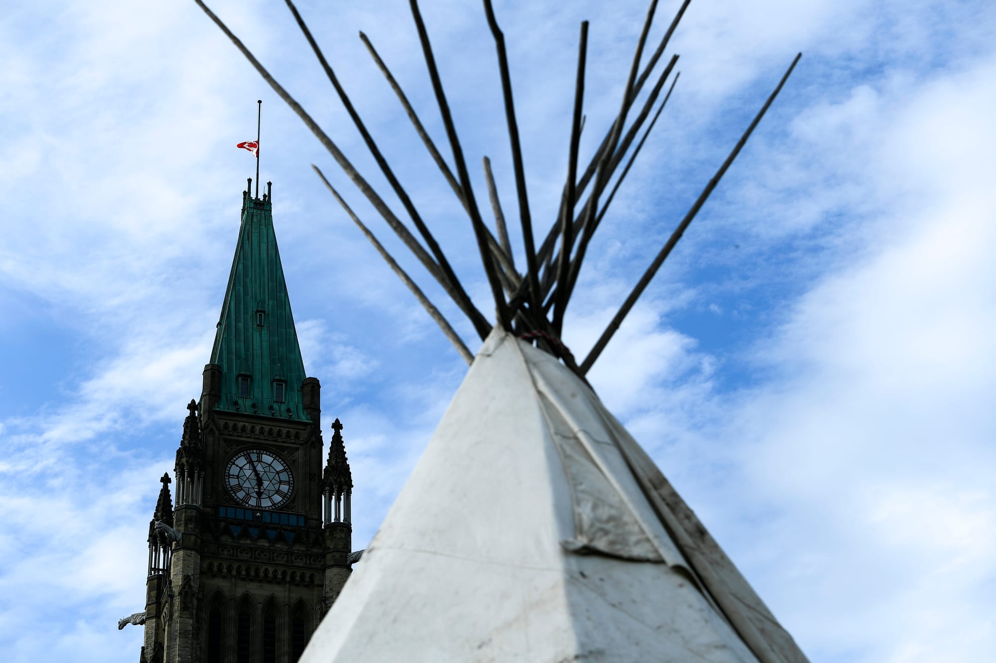 A teepee and one of the Parliament buildings are silhouetted against the sky during a protest in Ottawa in 2021.