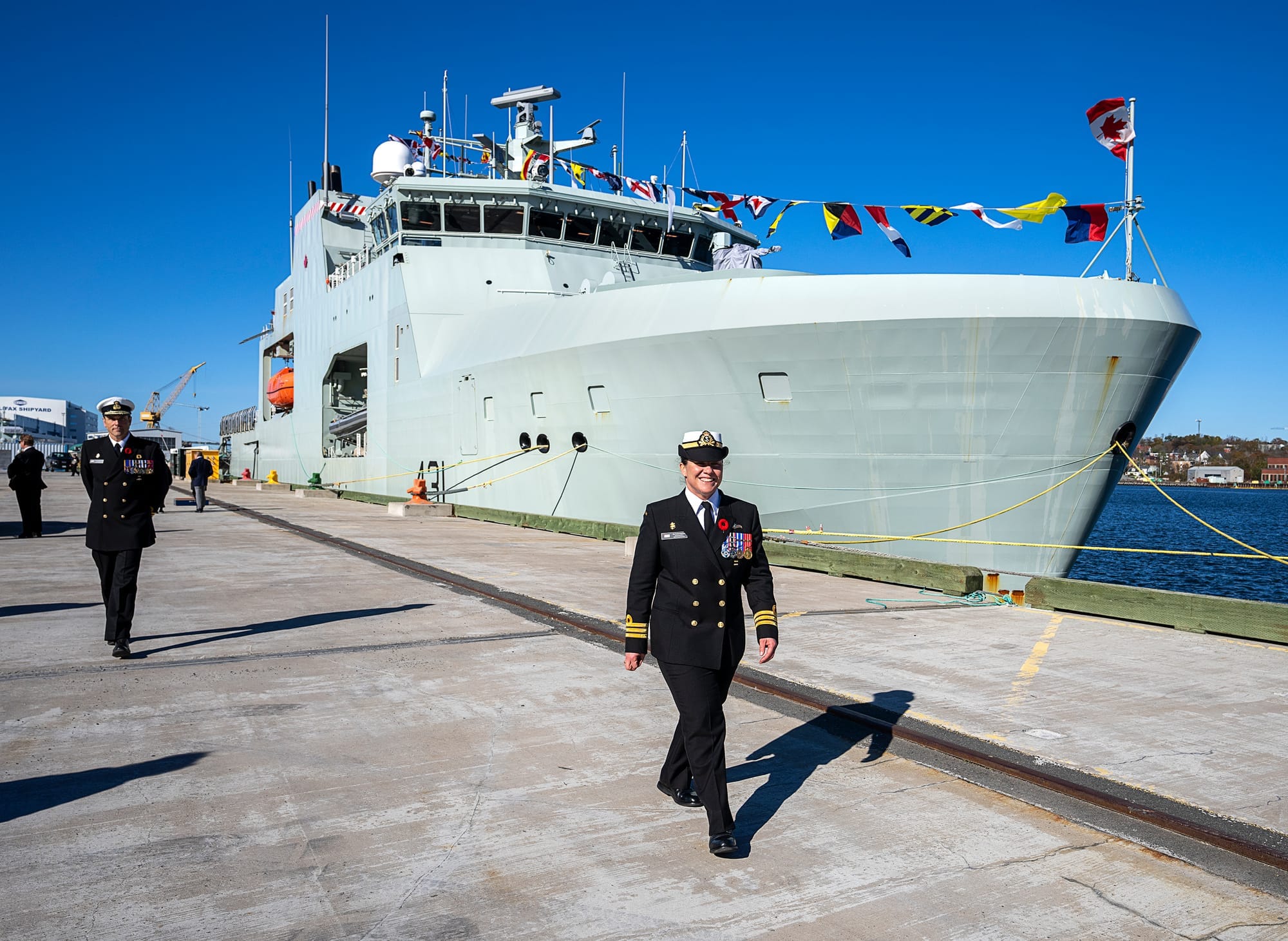Navy commander Vice-Admiral Angus Topshee and Cmdr. Nicole Robichaud, walk down the jetty at the HMCS Margaret Brooke's commissioning ceremony in Halifax.