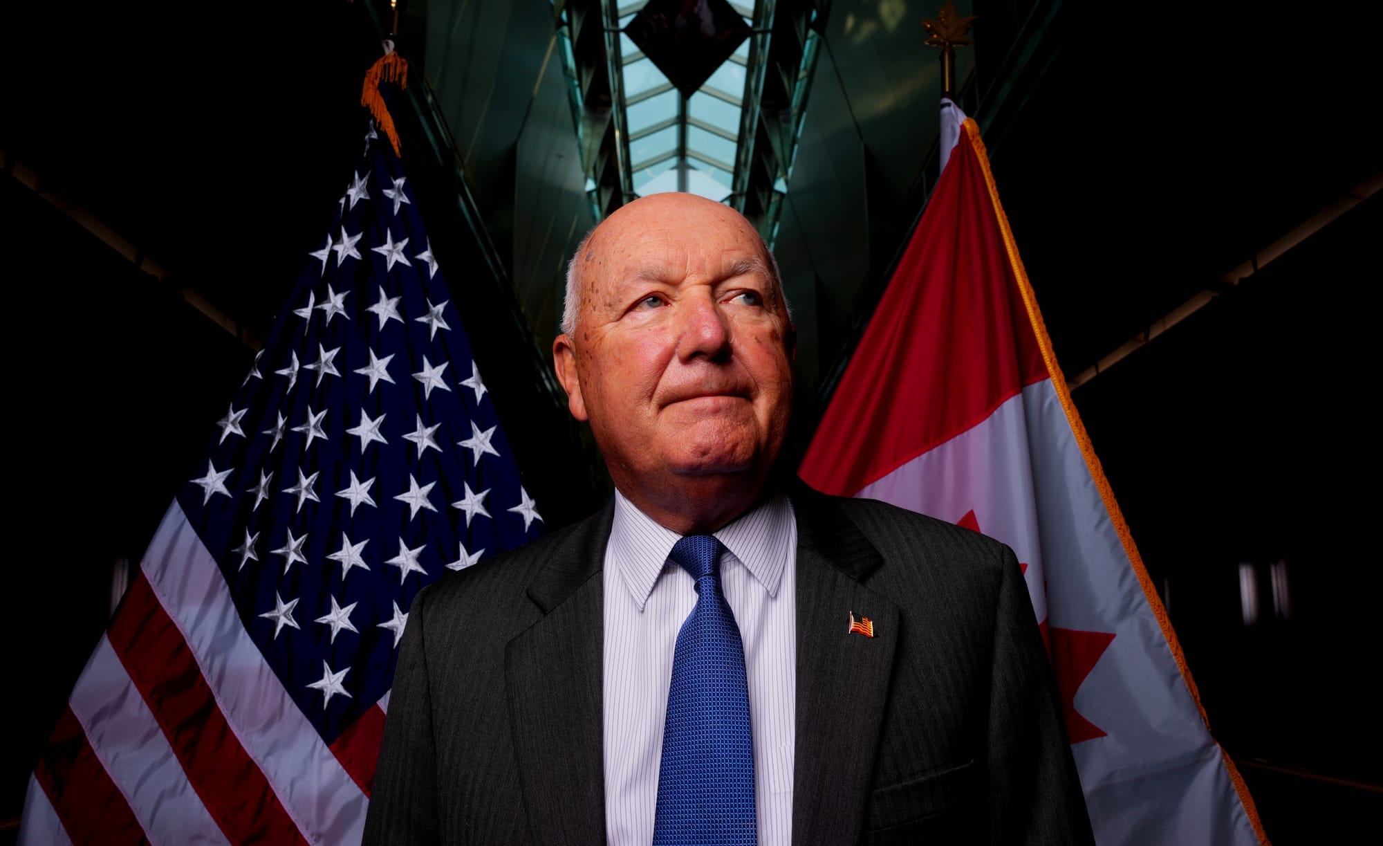 U.S. Ambassador to Canada Pete Hoekstra stands in front of a U.S. flag crossed with a Canadian flag at the U.S. Embassy in Ottawa.