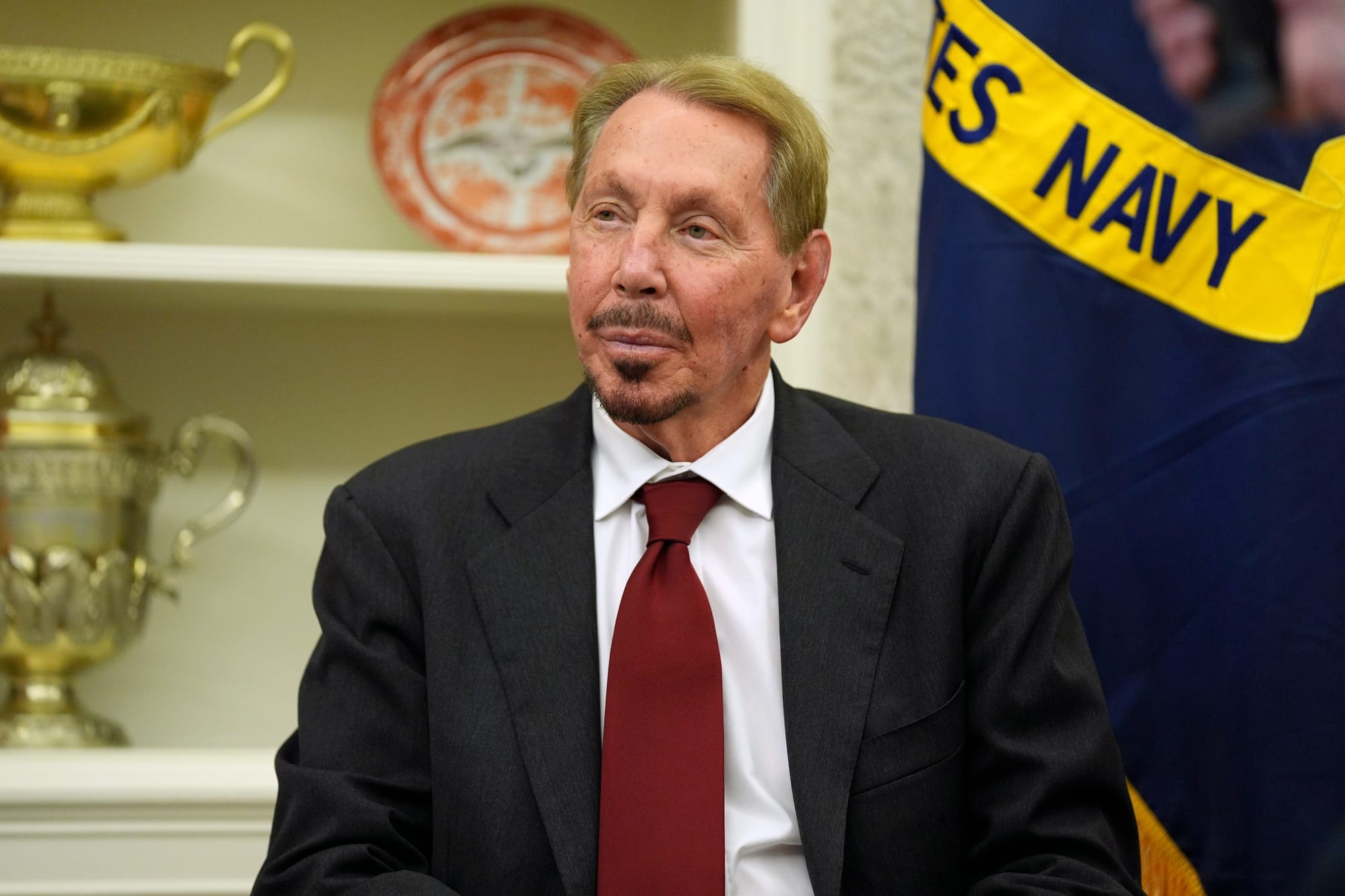 Larry Ellison, an older man with a goatee, sits in the Oval Office of the White House.
